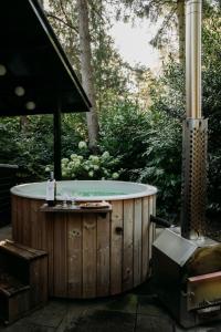 a jacuzzi tub in the woods with a grill at Forest Bungalow 1 - Hottub - Nature - Relax in Rheezerveen