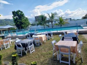 um grupo de mesas e cadeiras junto a uma piscina em Complejo Deportivo Wilson Palacios em La Ceiba
