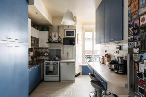 una cucina con armadi blu e piano di lavoro di Charming apartment in the heart of Paris - Welkeys a Parigi