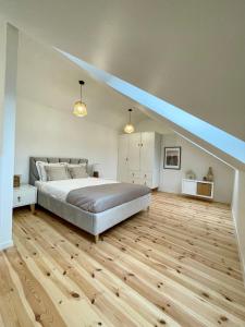 a large bedroom with a bed and wooden floors at Cozy House in Świnoujście