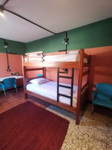 ブカラマンガにあるLa Bonita Guesthouseの赤いラグ付きのドミトリールームの二段ベッド2台