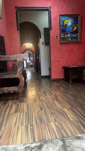 a room with a wooden floor and a red wall at Greenhouse Bolivia in La Paz