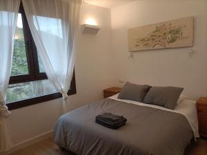 een slaapkamer met een bed en een raam bij El Mirador del Valle FACIL ACCESO con COCHE in Toledo