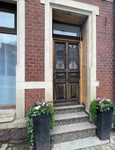 a door of a brick building with two potted plants at Blumenhaus in Idar-Oberstein