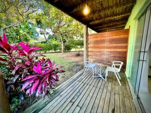 - une terrasse couverte avec une table et deux chaises dans l'établissement Bangalô Villas do pratagy com jacuzzi c, à Maceió