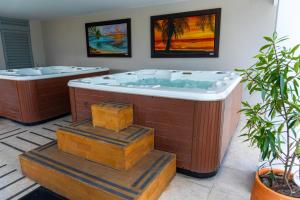 a jacuzzi tub in a room with two plants at Hotel Central Plaza Medellin in Medellín