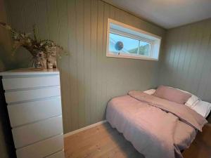 ein kleines Schlafzimmer mit einem Bett und einem Fenster in der Unterkunft Island life! 2,5 bedroom house. in Vigra