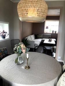 ein Wohnzimmer mit einem Tisch und einer Blumenvase in der Unterkunft Island life! 2,5 bedroom house. in Vigra