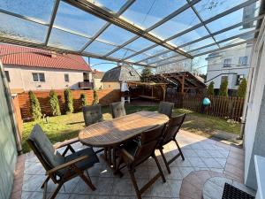 einen Holztisch und Stühle auf einer Terrasse in der Unterkunft Felix Villa in Nyíregyháza