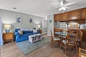 ein Wohnzimmer mit einem blauen Sofa und einem Tisch in der Unterkunft Ship Watch Pointe II N106 - 2nd Row - Shore Drive in Myrtle Beach