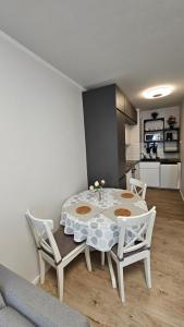 a dining room with a table and chairs and a kitchen at Apartament Anastazja FREE PARKING in Krakow