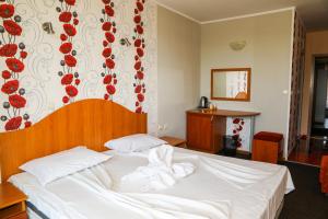 1 dormitorio con 1 cama con toallas en Family hotel Deykin, en Sunny Beach