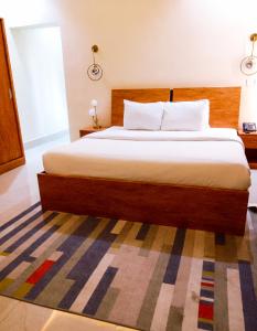a bedroom with a large bed with a wooden headboard at Address hotel and towers Abuja in Abuja