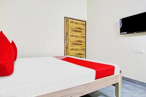 ein Schlafzimmer mit einem Bett und einem TV an der Wand in der Unterkunft OYO Flagship Skyway Residency in Indraprast
