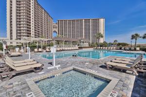 a swimming pool with lounge chairs and a resort at Ocean Creek Resort E8 -Oceanfront - Windy Hill in Myrtle Beach