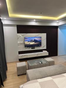 a living room with a flat screen tv on a wall at Grand DLF Stays in Lucknow