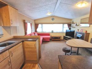 eine Küche und ein Wohnzimmer mit einem Sofa und einem Tisch in der Unterkunft Charming Static Caravan in Dawlish Warren