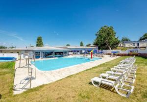 una piscina con tumbonas junto a un edificio en Charming Static Caravan, en Dawlish Warren