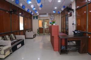 a lobby with couches and a table and blue balloons at Hotel Diamond AC Dormitory and Guest House in Surat