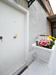 a toilet with flowers in it next to a door at INCANTO Apartament in Naples