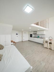 a large white room with a bed and a kitchen at INCANTO Apartament in Naples