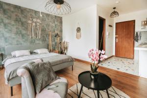 a bedroom with a bed and a table and a couch at Studio côté nature - trois épis de Turckheim in Turckheim