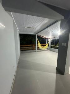 a large room with a balcony with a yellow hammock at Casa Liberdade in Novo Hamburgo