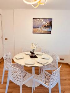 a white dining room table with white chairs and a table at RELAX HOME Maison et studio ensemble in Deauville