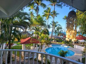 een balkon met uitzicht op het zwembad van een resort bij Hotel Casa Coson in Las Terrenas