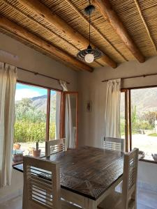 a dining room with a table and chairs and windows at Tierra Primitiva in Tilcara