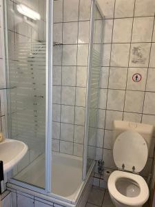 y baño con ducha, aseo y lavamanos. en Hotel Bender, en Eschweiler