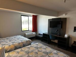 a hotel room with a bed and a desk with a television at Motel 6-San Diego, CA - Hotel Circle - Mission Valley in San Diego