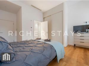 a bedroom with a large bed and a tv at Exquisite 3BR Duplex Period Conversion, Air-con & Amenities in London