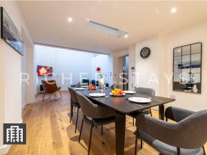 a dining room and living room with a table and chairs at Exquisite 3BR Duplex Period Conversion, Air-con & Amenities in London