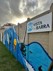 uma cerca com um sinal na lateral de um edifício em Pousada Vista da Barra em Cassino