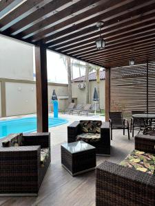 um pátio com mobiliário de vime e uma piscina em Pousada Vista da Barra em Cassino