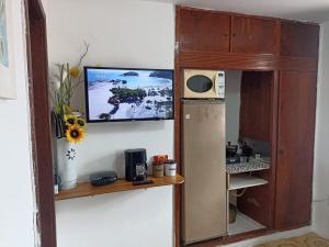 kuchnia z lodówką i telewizor na ścianie w obiekcie Refúgio Piratininga 202 w mieście Niterói