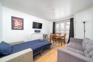 a living room with a bed and a couch at Spacious 1 Bed Flat in Dalston in London