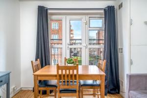 comedor con mesa, sillas y ventana en Spacious 1 Bed Flat in Dalston, en Londres