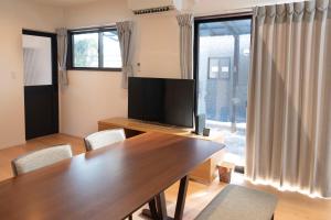 a dining room with a table and a television at 一棟貸しnuevoL7～暮らすように泊まる北群馬の冒険はここから in Numata