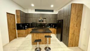 a kitchen with wooden cabinets and a black counter top at Magnifica habitacion Ecohotel !!! in Llanitos