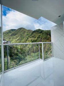 a room with three windows with a view of a mountain at Hostal Balcon del Cielo in Baños
