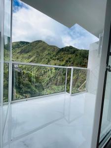 a room with windows with a view of a mountain at Hostal Balcon del Cielo in Baños