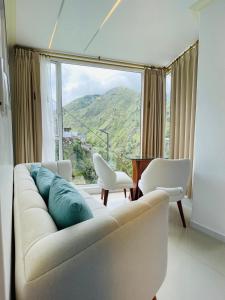 uma sala de estar com um sofá e uma grande janela em Hostal Balcon del Cielo em Baños
