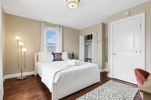 a bedroom with a white bed and a window at Housepitality - The Columbus Game House - 2 BR in Columbus