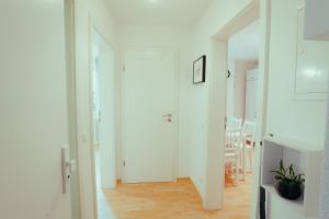 パッサウにある*Zentrumsnahe Wohlfühl-2-Zimmer-Wohnung*の白いドア付きの廊下、ダイニングルーム