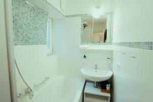 パッサウにある*Zentrumsnahe Wohlfühl-2-Zimmer-Wohnung*の洗面台と鏡のある白いバスルーム