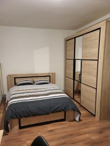 a bedroom with a large bed and a dresser at 2 chambres chez l'habitant in Poitiers