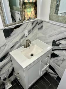 a white sink in a bathroom with marble walls at Iron Bound Gem in Newark