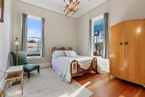 1 dormitorio con 1 cama, 1 silla y ventanas en Barclay Klum House by WanderLodges, en Ashland